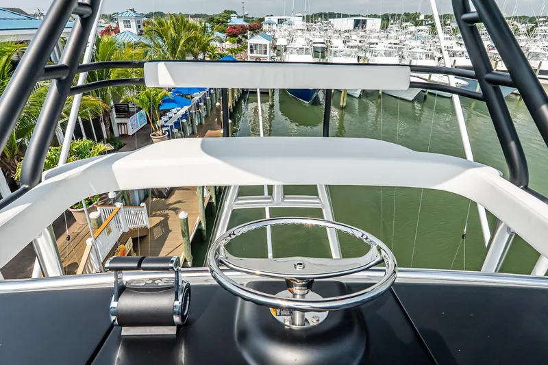 Slide: The Image of Helm view of 2025 Viking 64 Convertible yacht docked at marina. - 65
