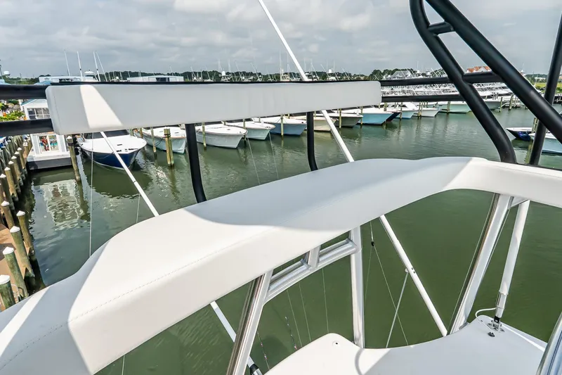 Slide: The Image of 2025 Viking 64 Convertible yacht overlooking marina with docked boats. - 67