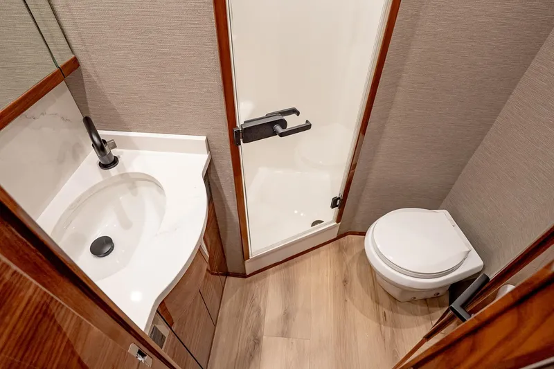 Slide: The Image of Luxurious bathroom in 2026 Viking 64 Convertible yacht with modern fixtures and wood accents. - 78