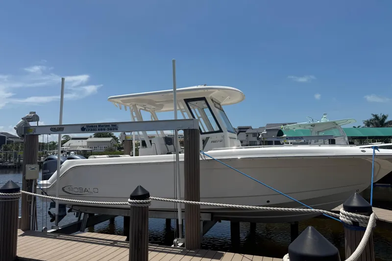 The Image of 2020 Robalo R272 Center Console boat docked at marina under clear blue sky. - 0