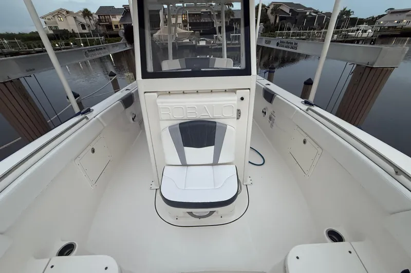 Slide: The Image of 2020 Robalo R272 Center Console boat interior at dock, showcasing seating and console. - 15