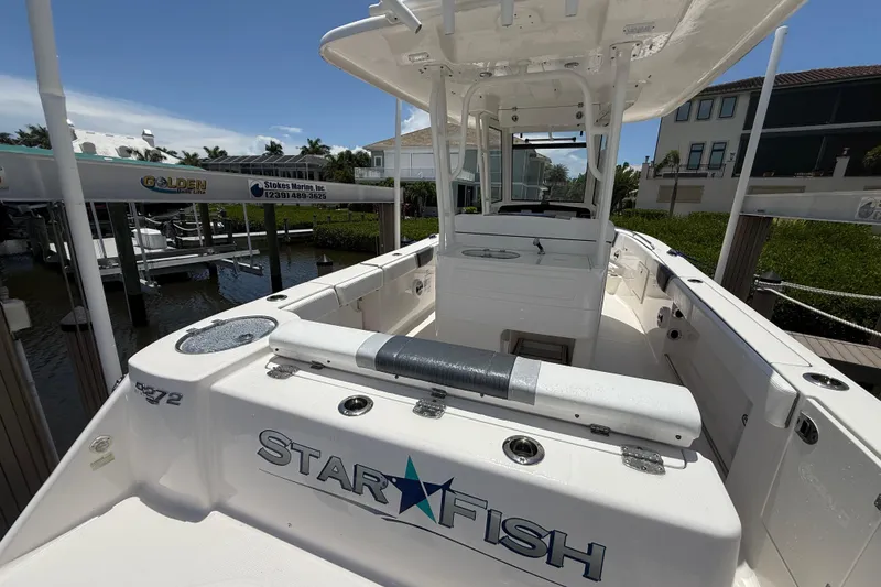 Slide: The Image of 2020 Robalo R272 Center Console boat docked, featuring spacious deck and modern design. - 2