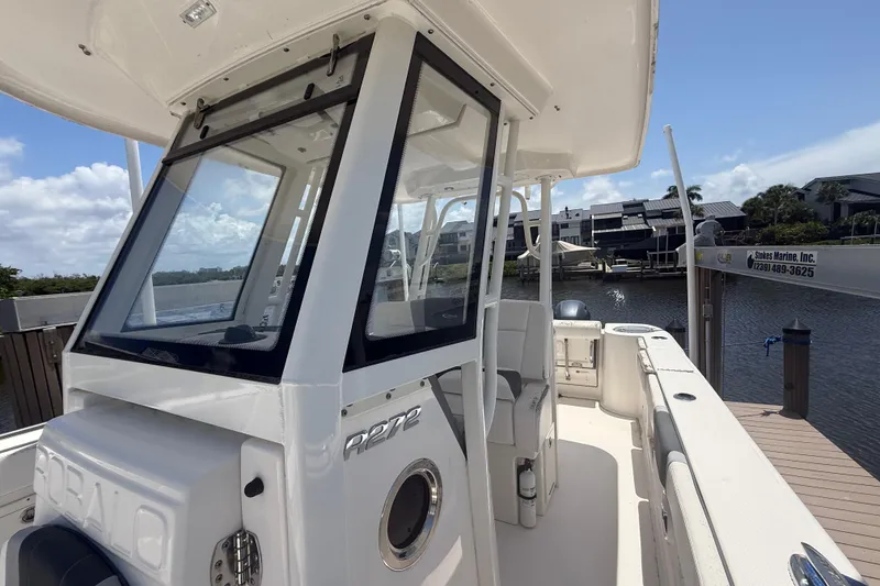 Slide: The Image of 2020 Robalo R272 Center Console boat docked by waterfront homes. - 22