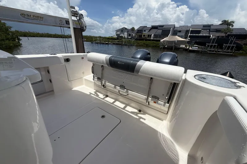 Slide: The Image of 2020 Robalo R272 Center Console boat interior with dual engines, docked by waterfront homes. - 27