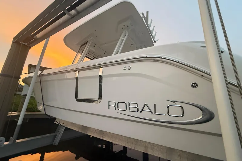 Slide: The Image of 2020 Robalo R272 Center Console boat at sunset, docked on a lift. - 3