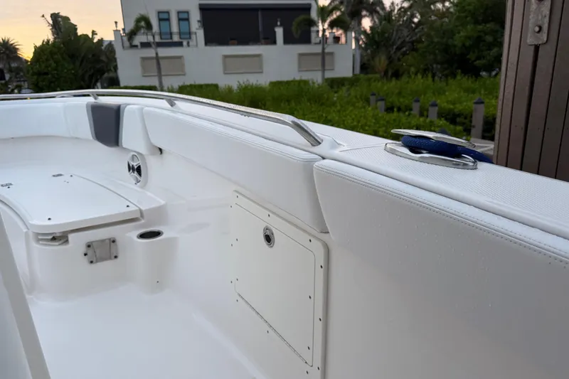 Slide: The Image of 2020 Robalo R272 Center Console boat interior with white seating and storage compartments. - 32