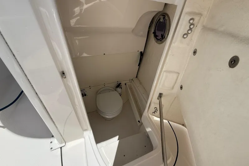 Slide: The Image of 2020 Robalo R272 Center Console boat interior with compact marine toilet. - 35