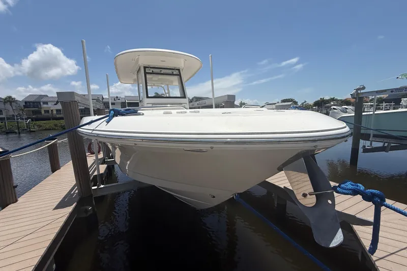 Slide: The Image of 2020 Robalo R272 Center Console boat docked at marina under clear sky. - 38