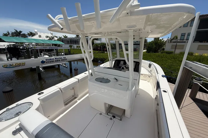 Slide: The Image of 2020 Robalo R272 Center Console boat docked at marina, featuring spacious deck and helm. - 4