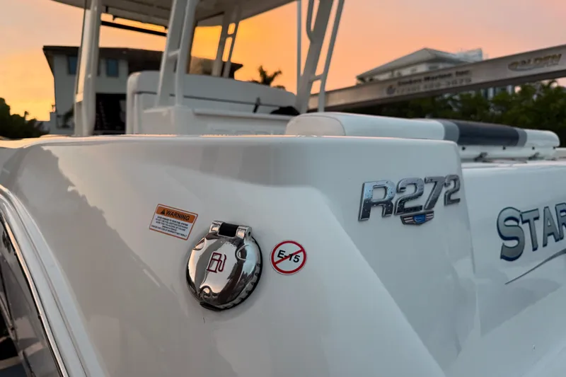 Slide: The Image of 2020 Robalo R272 Center Console boat at sunset, showcasing sleek design and branding. - 6