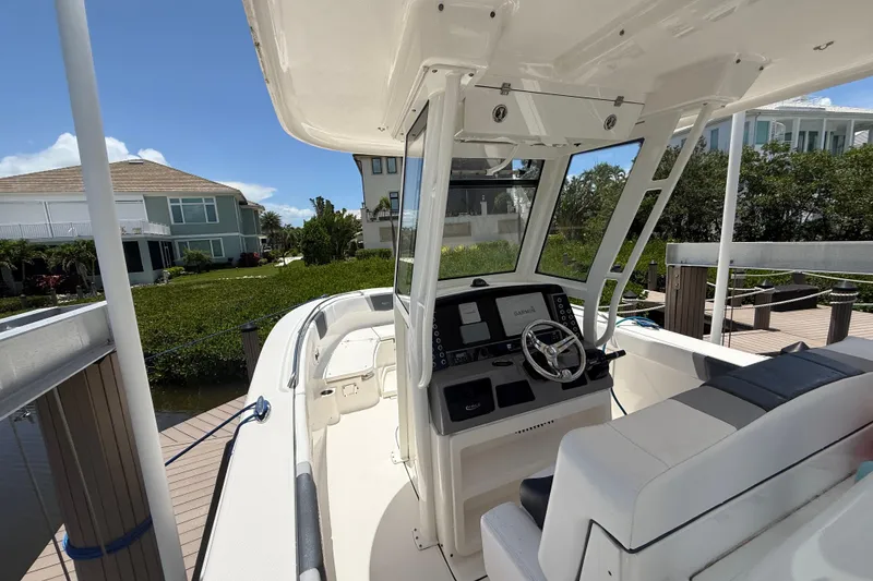 Slide: The Image of 2020 Robalo R272 Center Console boat docked, featuring a sleek helm and modern design. - 7