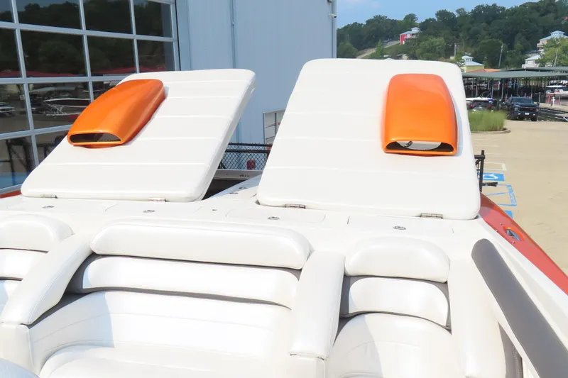 Slide: The Image of Luxury MTI 42 boat with white seating and orange accents, docked outdoors. - 16