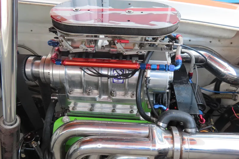 Slide: The Image of High-performance engine of a 2003 MTI 42 boat, featuring polished components and intricate piping. - 25