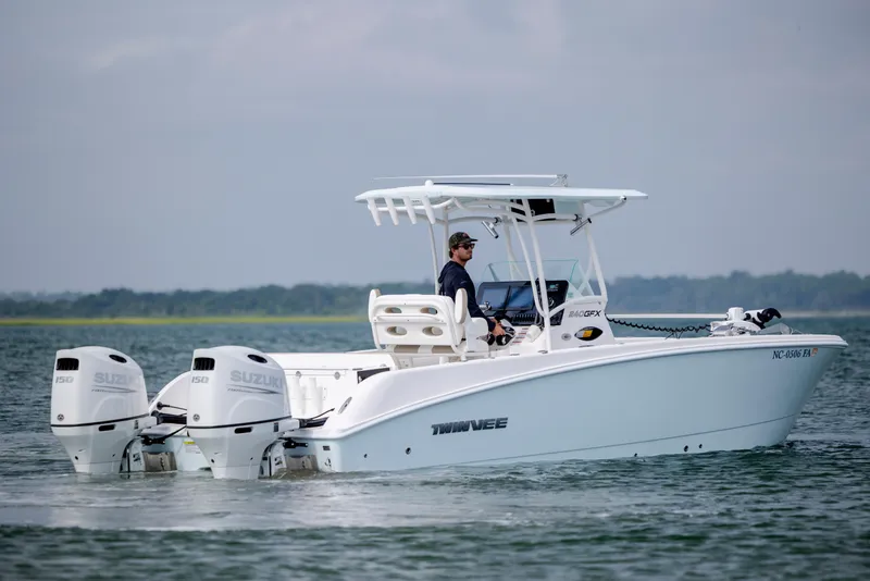 Slide: The Image of 2023 Twin Vee 240 GFX CC boat with dual Suzuki engines on calm water. - 10
