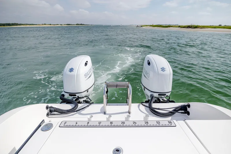 Slide: The Image of 2023 Twin Vee 240 GFX CC boat with dual Suzuki outboard motors on open water. - 11