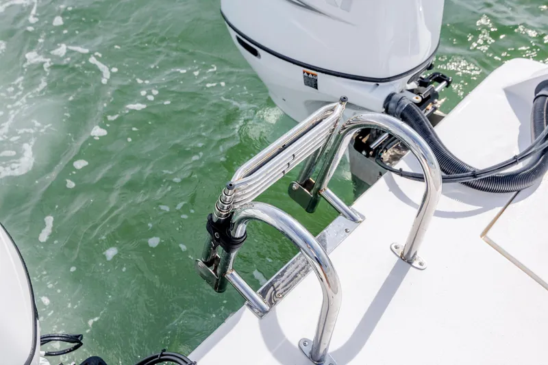 Slide: The Image of 2023 Twin Vee 240 GFX CC boat with stainless steel ladder and outboard motor on water. - 12