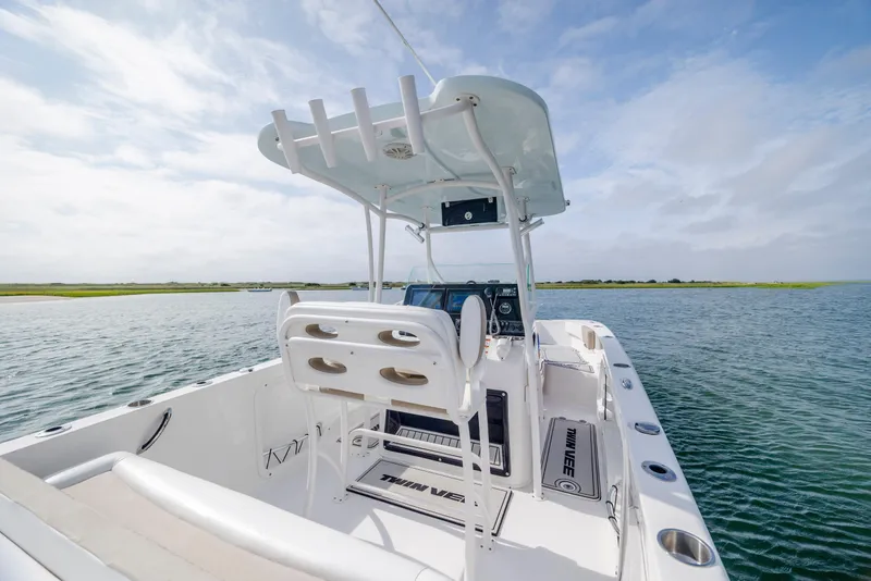 Slide: The Image of 2023 Twin Vee 240 GFX CC boat on calm water, featuring sleek design and modern console. - 14