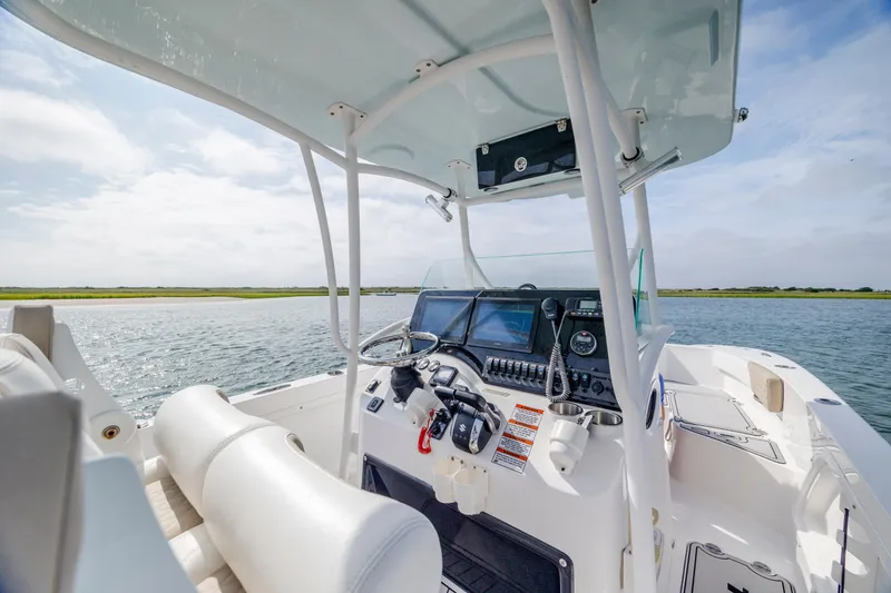 Slide: The Image of 2023 Twin Vee 240 GFX CC boat interior with steering console on a sunny day. - 16