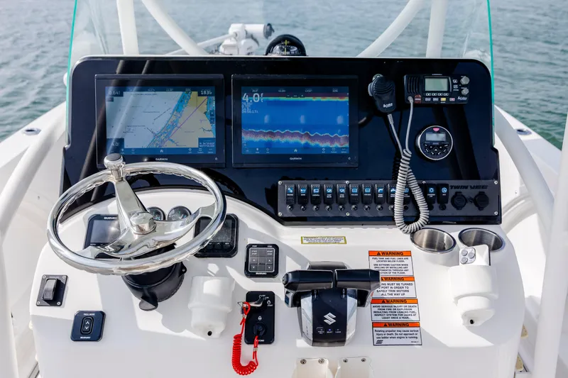 Slide: The Image of 2023 Twin Vee 240 GFX CC boat dashboard with navigation screens and controls. - 17