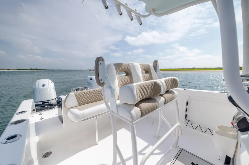 Slide: The Image of 2023 Twin Vee 240 GFX CC boat interior with seating, on calm water. - 18