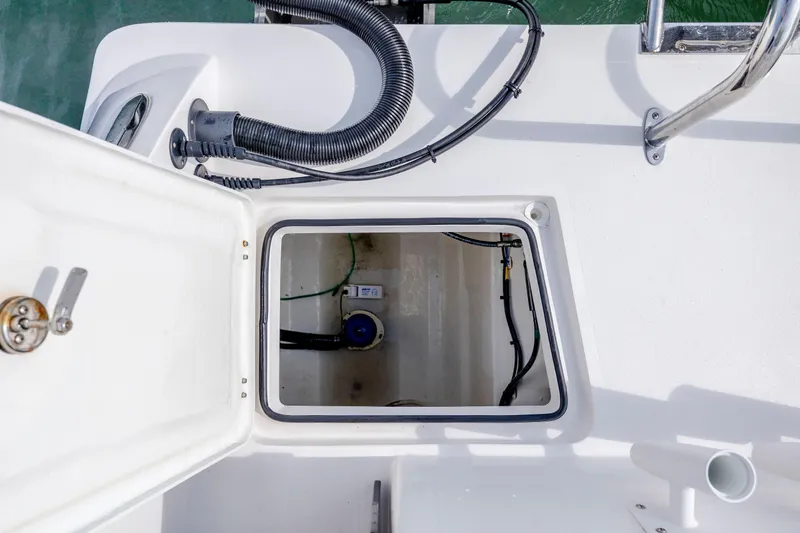 Slide: The Image of Open hatch on 2023 Twin Vee 240 GFX CC boat deck, showing internal compartment. - 20