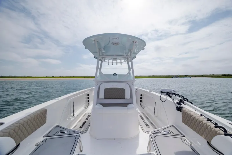 Slide: The Image of 2023 Twin Vee 240 GFX CC boat on calm water under a cloudy sky. - 23