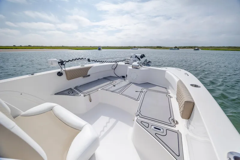Slide: The Image of 2023 Twin Vee 240 GFX CC boat on calm water, featuring spacious deck and seating. - 25