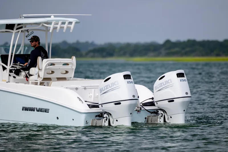 Slide: The Image of 2023 Twin Vee 240 GFX CC boat with dual Suzuki 150 engines on water. - 7