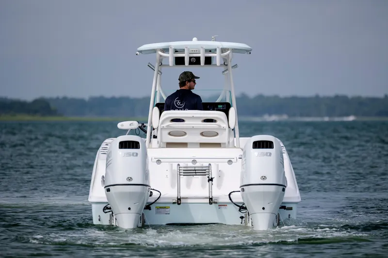 Slide: The Image of 2023 Twin Vee 240 GFX CC boat cruising on open water, rear view. - 9