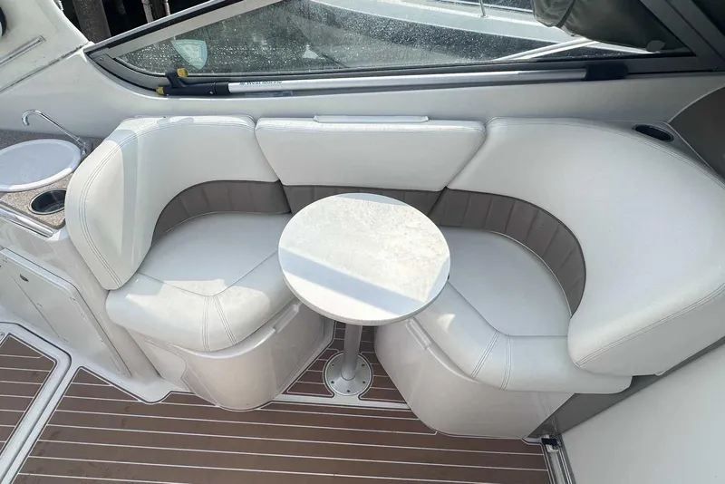 Slide: The Image of 2004 Four Winns 298 Vista boat interior with white seating and small round table. - 11