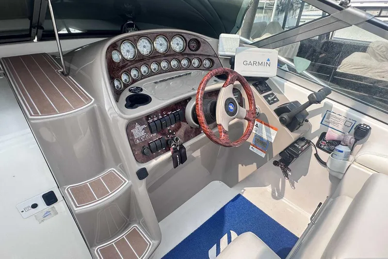 Slide: The Image of 2004 Four Winns 298 Vista boat cockpit with Garmin navigation and wood-accented steering wheel. - 14