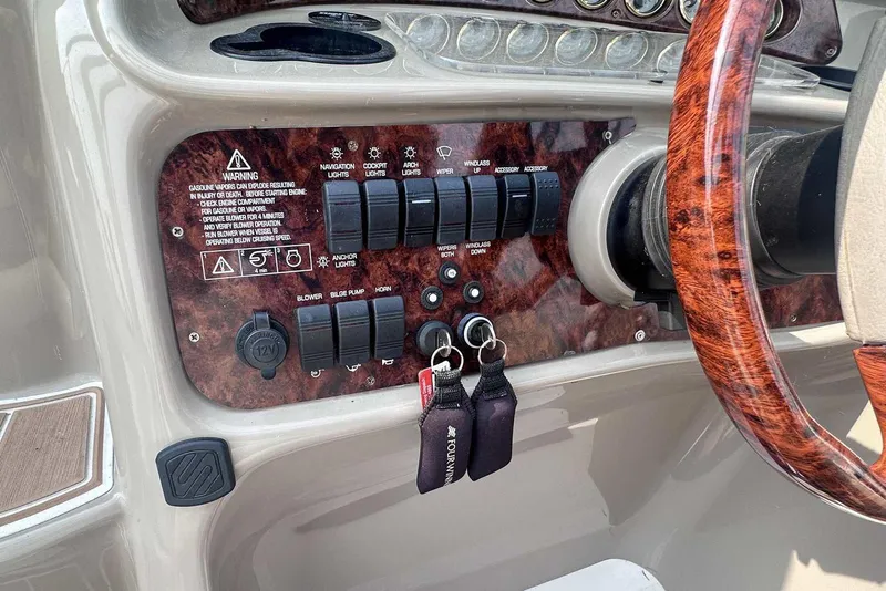 Slide: The Image of 2004 Four Winns 298 Vista dashboard with wood trim and control switches. - 18
