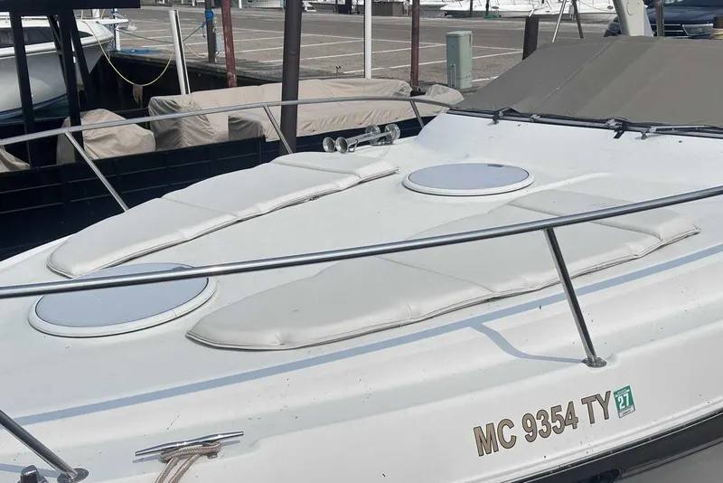 Slide: The Image of 2004 Four Winns 298 Vista boat with cushioned deck, docked at marina. - 2