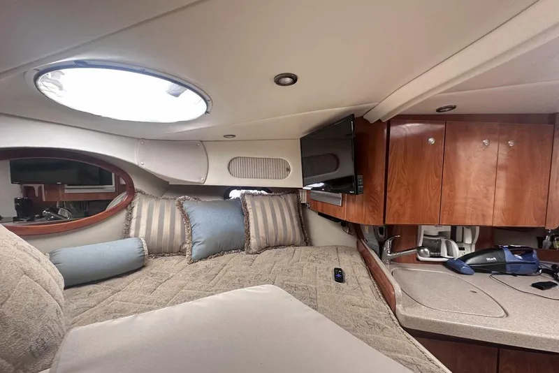 Slide: The Image of Interior of 2004 Four Winns 298 Vista boat with cozy bed and wooden cabinets. - 26