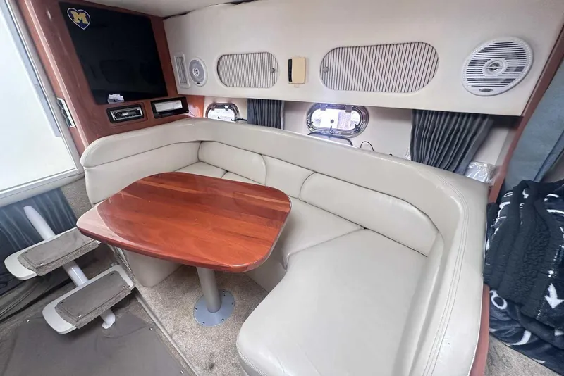 Slide: The Image of 2004 Four Winns 298 Vista boat interior with beige seating and wooden table. - 37