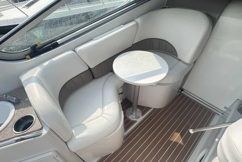 Slide: The Image of 2004 Four Winns 298 Vista boat interior with white seating and small table. - 9