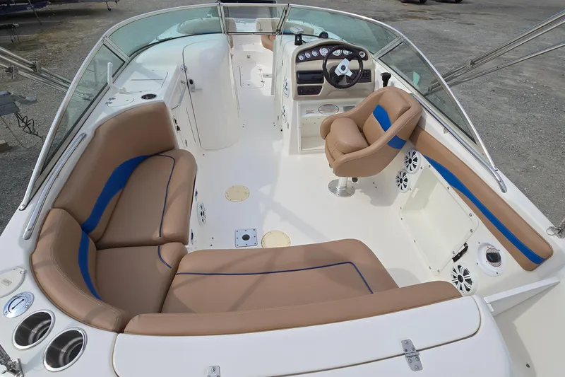 Slide: The Image of 2001 Chaparral Sunesta 233 boat interior with tan and blue seating, steering wheel, and dashboard. - 18