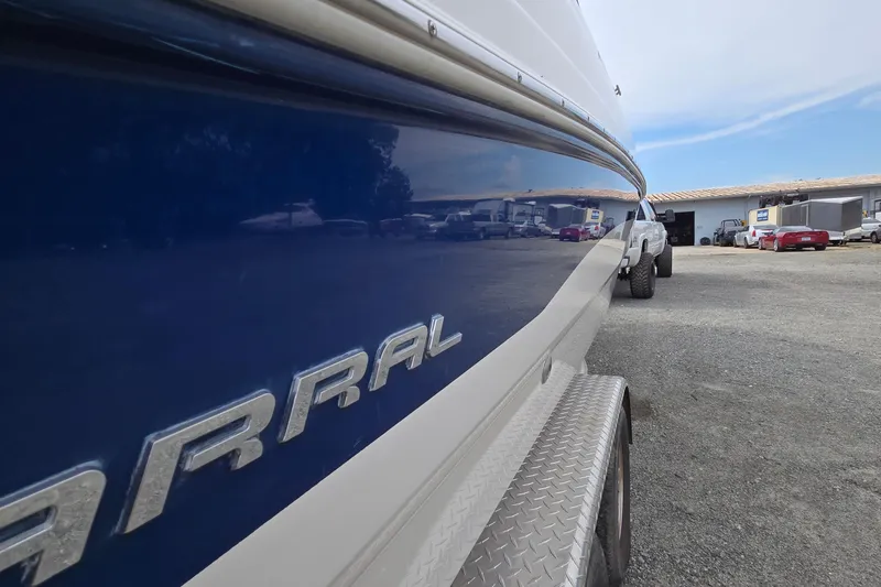 Slide: The Image of 2001 Chaparral Sunesta 233 boat on trailer, reflecting vehicles and buildings. - 2