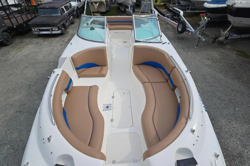 Slide: The Image of 2001 Chaparral Sunesta 233 boat with spacious seating, parked on gravel lot. - 22