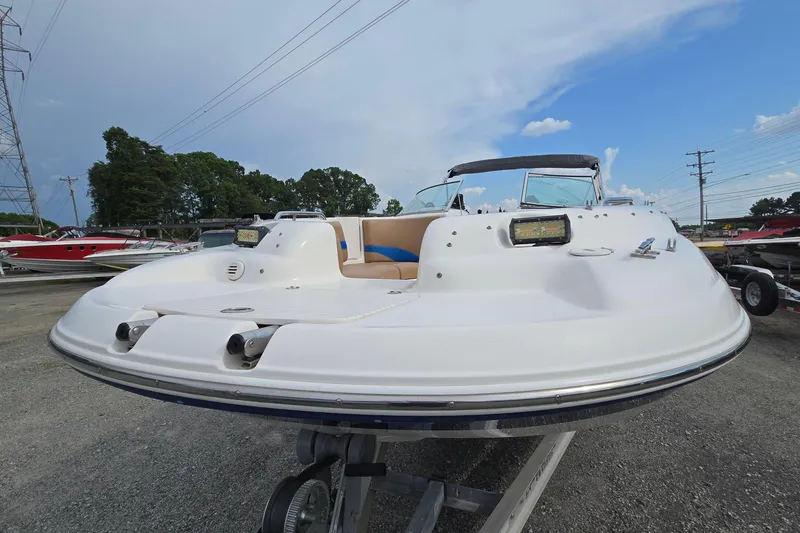Slide: The Image of 2001 Chaparral Sunesta 233 boat on trailer, outdoor display, clear sky background. - 23