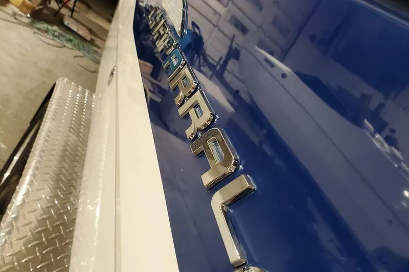 Slide: The Image of 2001 Chaparral Sunesta 233 boat with chrome logo and blue hull in a garage. - 3