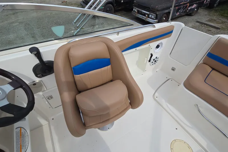Slide: The Image of 2001 Chaparral Sunesta 233 boat interior with tan and blue seating, steering wheel, and controls. - 34
