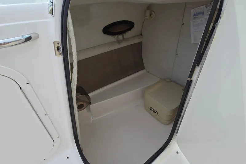 Slide: The Image of 2001 Chaparral Sunesta 233 boat interior with compact toilet and storage space. - 39