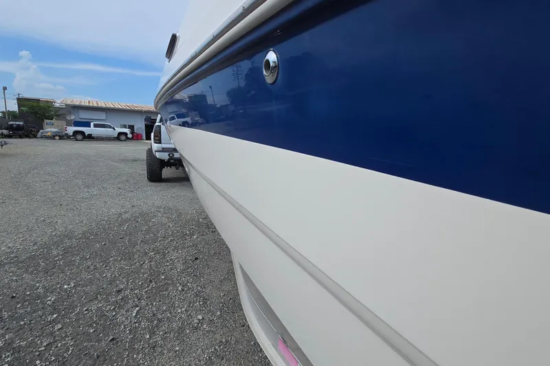 Slide: The Image of 2001 Chaparral Sunesta 233 boat side view, parked on gravel lot. - 4