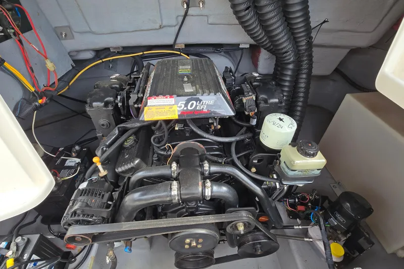Slide: The Image of Engine compartment of a 2001 Chaparral Sunesta 233 boat, featuring a 5.0-liter engine. - 49