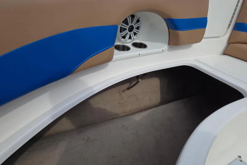Slide: The Image of 2001 Chaparral Sunesta 233 boat interior with blue and tan seating, speaker, and cup holders. - 54
