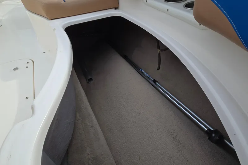 Slide: The Image of Storage compartment in 2001 Chaparral Sunesta 233 boat, featuring a telescopic pole. - 55