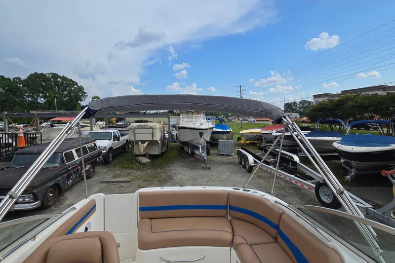 Slide: The Image of 2001 Chaparral Sunesta 233 boat with bimini top in a marina, surrounded by other boats. - 58