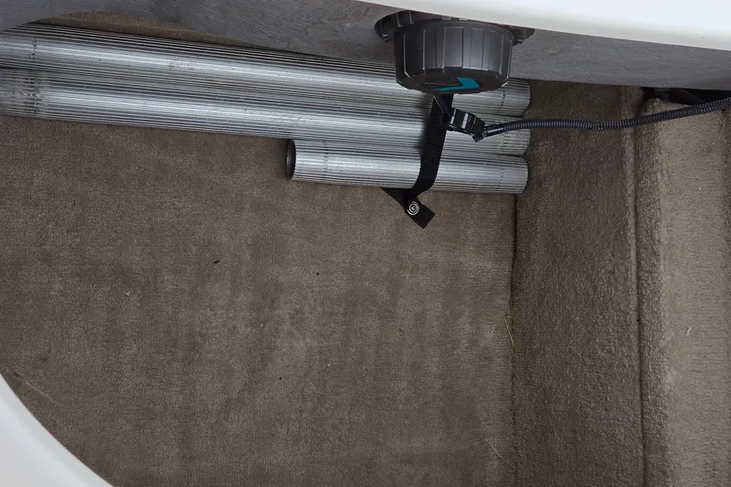 Slide: The Image of 2001 Chaparral Sunesta 233 storage compartment with metal rods and carpeted interior. - 64