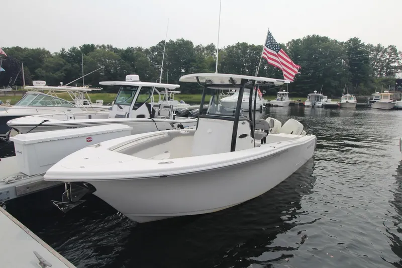 The Image of 2020 Sea Pro 259 Center Console boat docked with American flag, surrounded by other boats. - 1